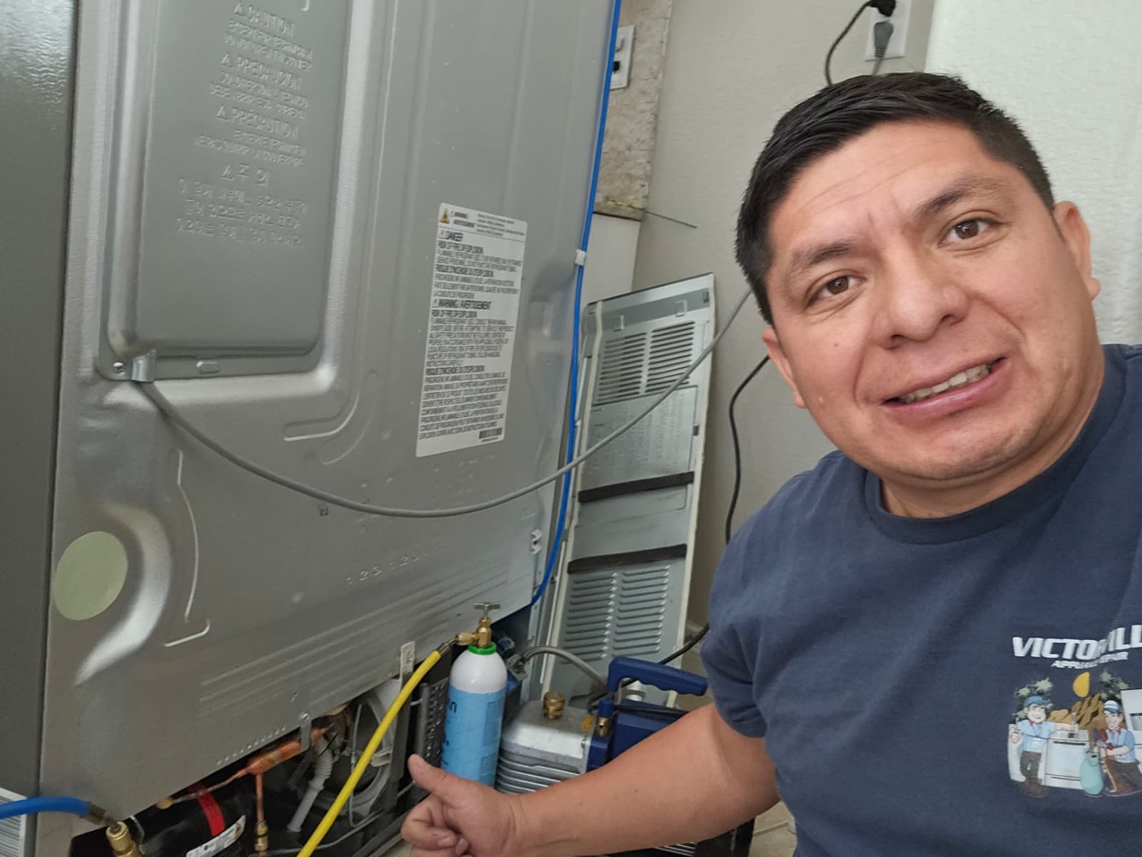 Appliance repair technician working on refrigerator in Barstow